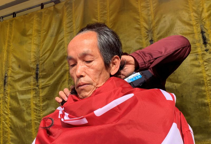 Unionised truck driver has his hair shaved at a head-shaving protest in Uiwang