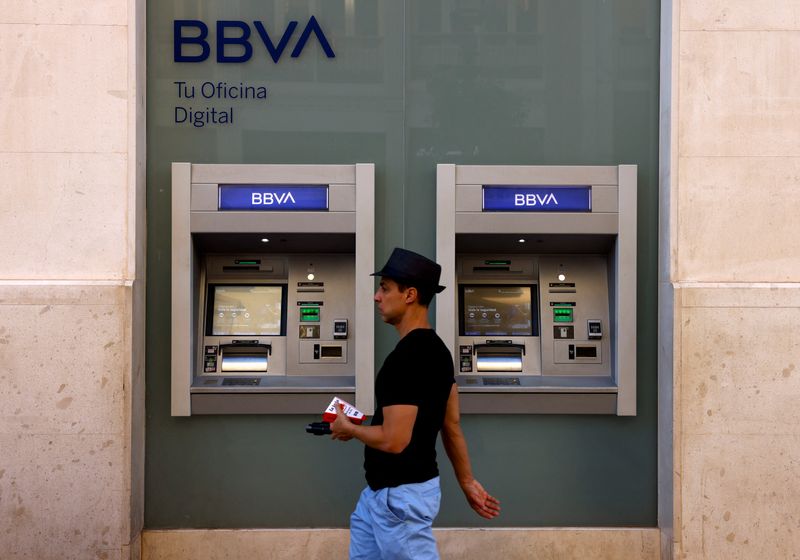 FOTO DE ARCHIVO. Un hombre pasa por delante de los cajeros automáticos de una sucursal bancaria del BBVA en Málaga, Andalucía, España