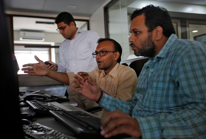 Brokers react while trading during the presentation of the federal budget at a stock brokerage firm in Mumbai