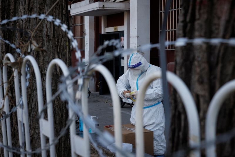 A pandemic control worker in a protective suit works in a partially locked-down residential compound as outbreaks of the coronavirus disease (COVID-19) continue in Beijing