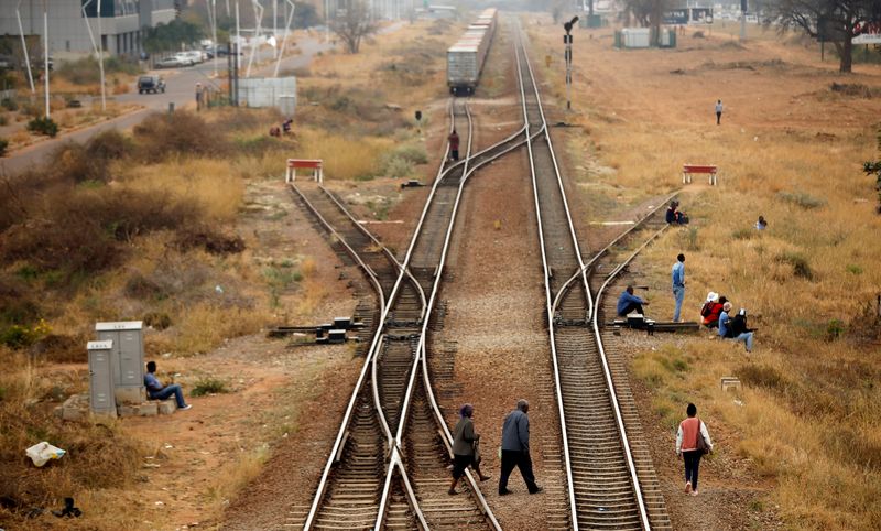 FILE PHOTO: People cross rail tracks in the Central Business District (CBD), in the capital Gaborone