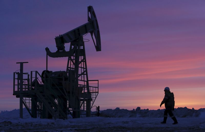 File photo of a worker walking past a pump jack on an oil field owned by Bashneft company near Nikolo-Berezovka