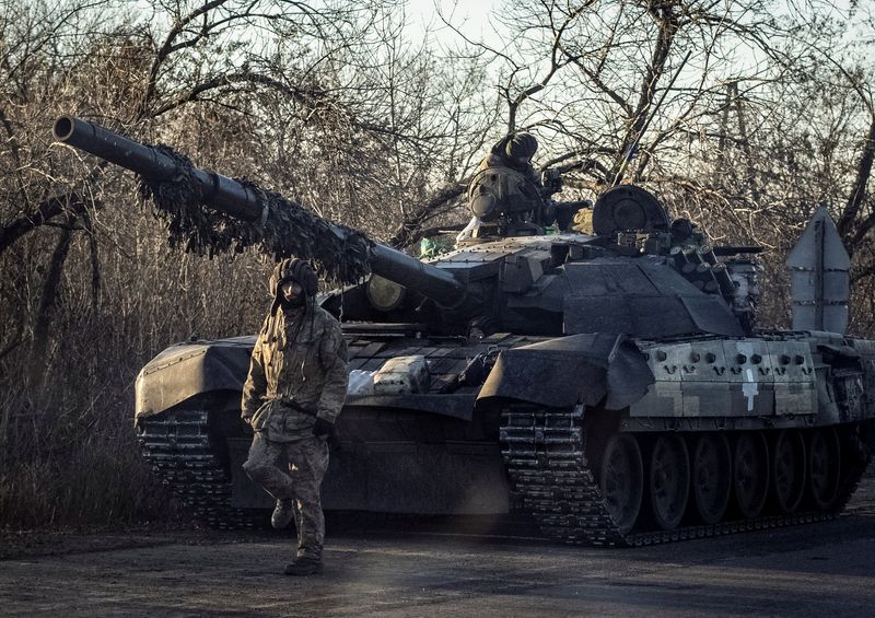 FILE PHOTO: Ukrainian serviceman walks near a tank in Bakhmut