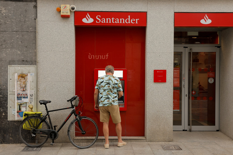 A man uses an ATM machine at a Santander bank branch in Ronda