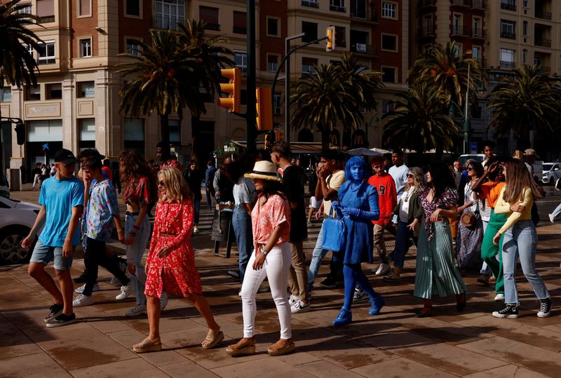 FILE PHOTO: People walk as they prepare to be extras for an Dutch advertising spot of fruit-flavoured beverages in central Malaga