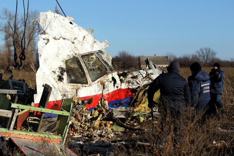 FILE PHOTO: Local workers transport a piece of wreckage from Malaysia Airlines flight MH17 at the site of the plane crash near the village of Hrabove (Grabovo) in Donetsk region