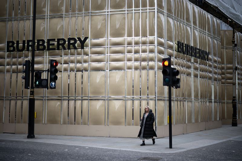 A person walks past a Burberry store undergoing refurbishment on New Bond Street in London