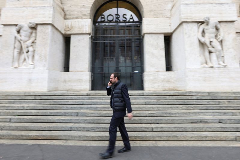 Un uomo davanti l'ingresso della Borsa di Milano